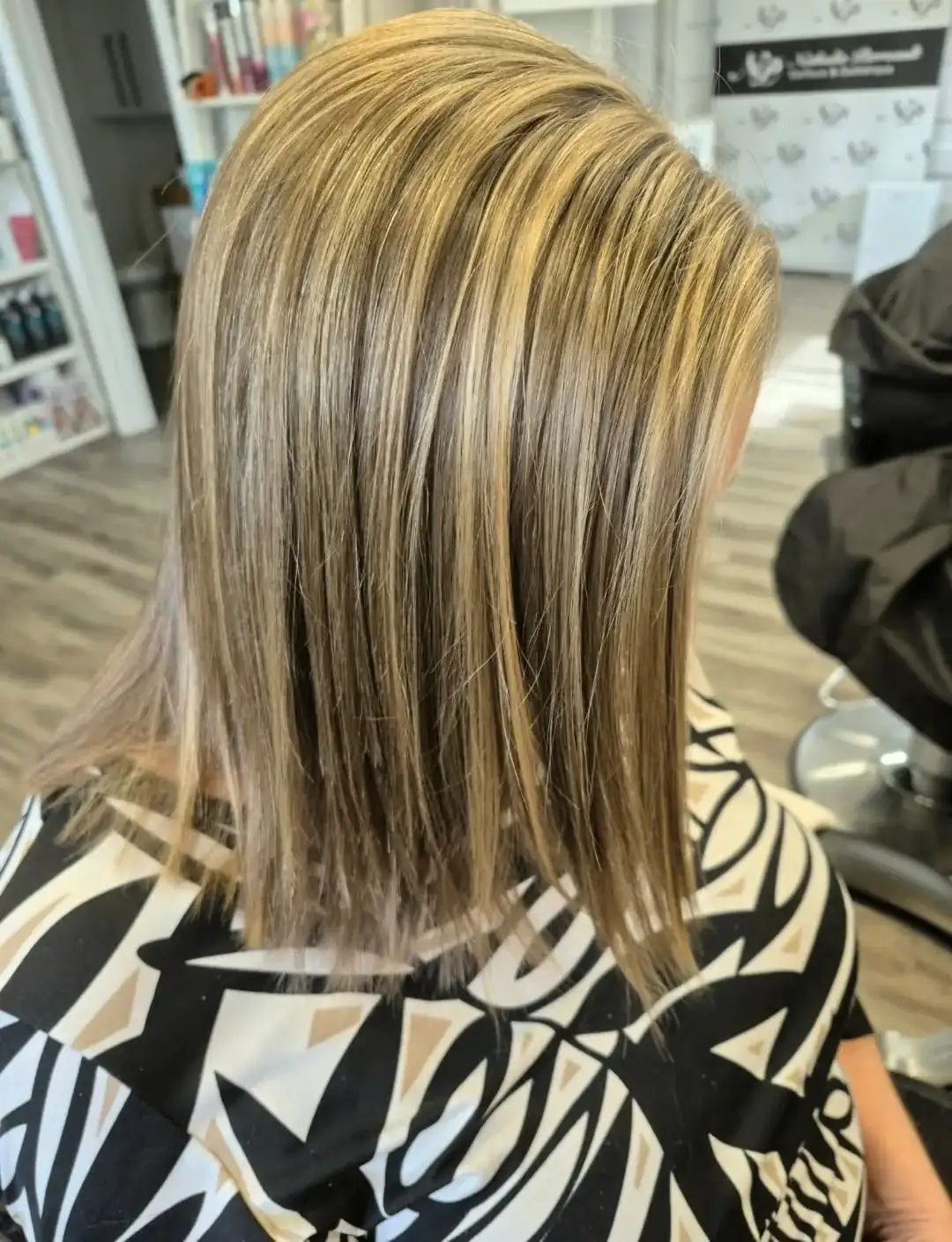 Carré dégradé avec mèches blondes, vu de dos, dans le salon